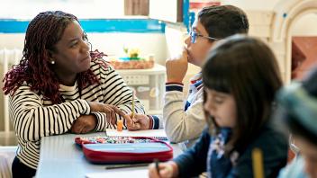 elementary teacher working with a small group of students in class