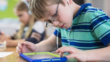 Elementary boy using tablet in class