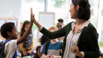 Elementary teacher giving a student a high-five for encouragement