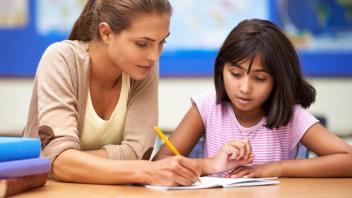 Female tutor working on-on-one with an elementary student on reading