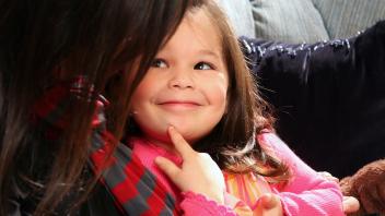 Preschool girl talking to her mother