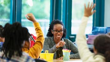 Teacher calling on students in elementary class