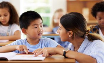 Elementary teacher working with student during reading instruction