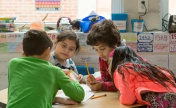 Diverse group of elementary students working on writing project