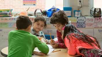 Diverse group of elementary students working on writing project
