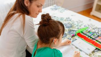 Young girl with hearing aid practicing reading