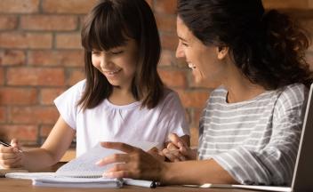 Mother and elementary age daughter working on homework together