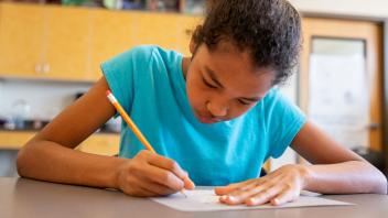 elementary girl completing a comprehension strategy graphic organizer