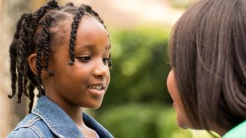 Closeup of mother speaking to elementary aged daughter
