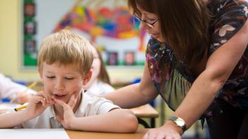 elementary age student talking one-on-one with his teacher