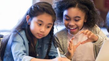 two young elementary students having a lively conversation in class