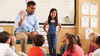 Male elementary teacher giving a lesson to the whole class